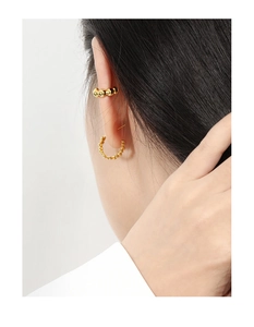 Close-up of a model wearing a gold beaded ear cuff and matching hoop earring