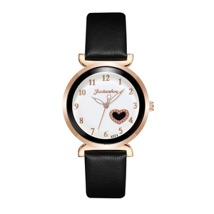 Detail of rose gold watch case with heart pattern on white dial and black leather strap
