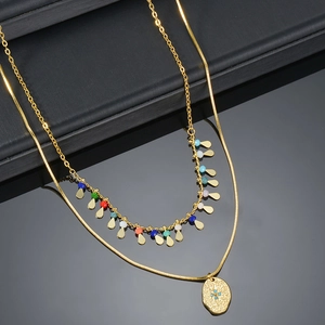 Detail of gold double-layer necklace with teardrop charms and North Star pendant