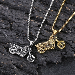 Hip hop stainless steel motorcycle pendants in gold and silver finish on rock surface