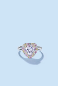 Macro shot of silver heart ring featuring a large clear stone and multi-color zircon accents