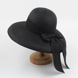 Dettaglio di un cappello di paglia nero a tesa larga con un grande ed elegante fiocco