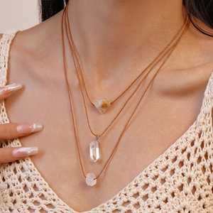 Close-up of three layered natural crystal pendants with adjustable wax cord straps