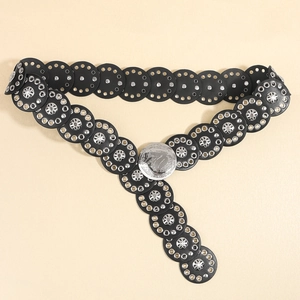Detail of western punk belt with black round leather discs and embossed silver buckle