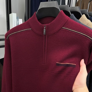 Detail of burgundy knit sweater with zipper collar and textured horizontal stripe patterns