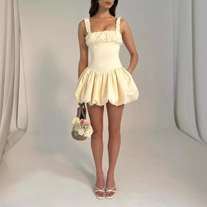 Détail de la robe crème avec texture satinée et buste froncé en vue frontale soignée