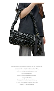 Macro detail of high-quality black woven cowhide leather handbag with tied strap design