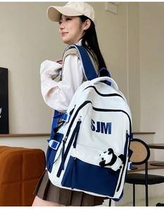 Detail view of large capacity blue and white backpack with panda plush and side buckles