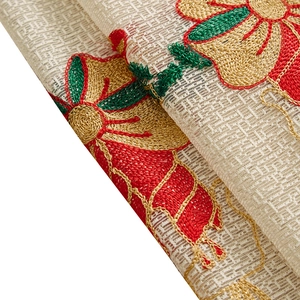 Detailed embroidery on American Christmas tablecloth featuring red and gold floral patterns