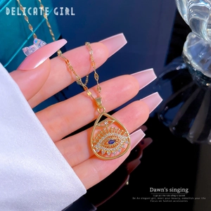 Macro shot of gold evil eye pendant with blue gemstone and micro-pave crystals