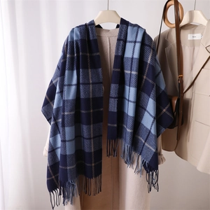 Close-up of blue and white plaid scarf with fringe on a beige winter coat