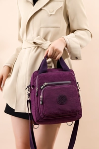Sac bandoulière en nylon violet avec écusson logo et texture détaillée à micro-rides