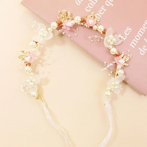 Vue détaillée du serre-tête floral pour enfants avec perles blanches et rubans roses
