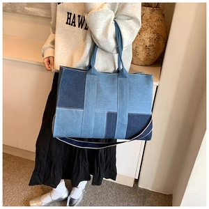 Detail of blue patchwork denim tote bag with spacious interior and bicolor shoulder strap