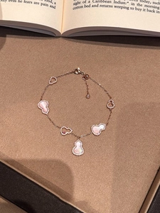 Detail of rose gold bracelet with pink shell and crystal hollow wulu charm pendants