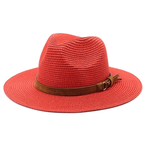 Detail of burgundy straw fedora hat featuring a brown suede band and gold metal buckle