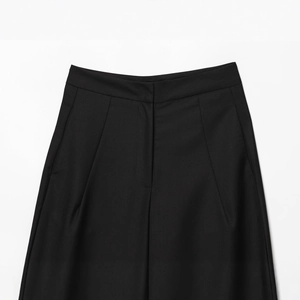 Gros plan sur un pantalon noir à taille haute montrant la texture du tissu en sergé