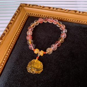 Detailed macro shot of natural rutilated quartz lotus bracelet on black velvet display