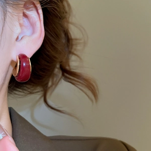 Close-up of vintage resin C-shaped earring with 18k gold plating on model's ear
