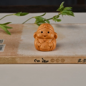 Vue détaillée d'une figurine Zhu Bajie en bois sculpté sur un livre ancien