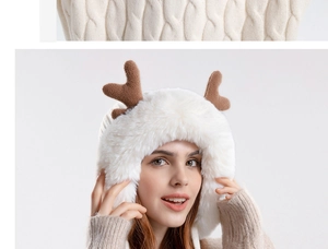 Detail of plush white winter hat with soft brown antlers and thick faux fur texture