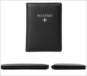 Close-up of black leather passport holder with RFID protection and white airplane icon