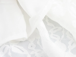 Détail macro du tissu en dentelle florale blanche avec coutures fines sur la robe