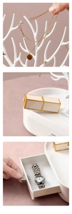 Close-up of white antler jewelry rack featuring hanging hooks and a storage drawer