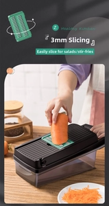 Detail of 3mm shredding blade on mandoline slicer with fresh carrots in a kitchen