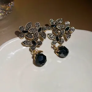 Vintage gold flower earrings with black crystal petals and faceted gemstone pendants