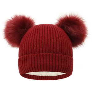Detail of burgundy knit beanie with double faux fur pom-poms and thick fleece lining