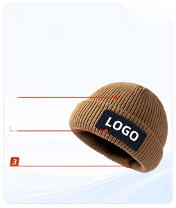 Close-up of the thick brown acrylic beanie showing ribbed knit texture and folded cuff