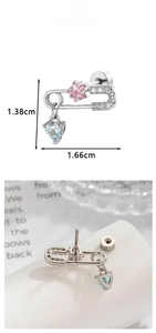 Macro shot of a paperclip stud earring with a pink star and blue heart pendant detail