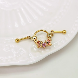 Makroaufnahme von vergoldetem Barbell-Ohrring mit rosa Herz-Zirkon und Schmetterling-Charm