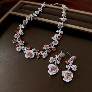 Close-up of vintage rose jewelry set featuring red stones and zircons on a tray