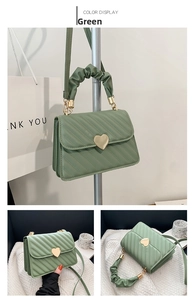 Close-up of green crossbody bag featuring heart-shaped gold lock and quilted texture
