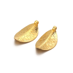 Two gold stainless steel leaf charms for DIY jewelry making on white background