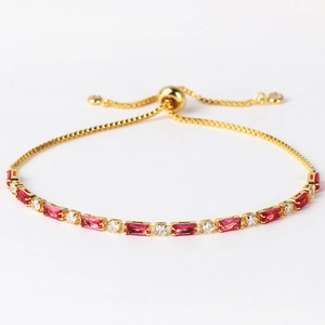 Detail of adjustable gold bracelet with alternating red emerald-cut and clear round gems