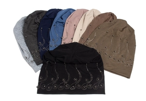 Flat lay of multiple color options for knit beanies with decorative silver bead patterns