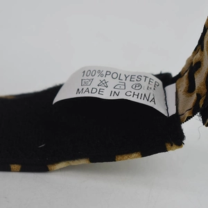 Detail view of the 100% polyester fabric care label on a leopard print sun hat