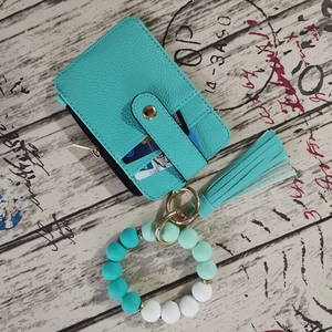 Detail of mint green card holder with silicone beads bracelet and tassel keychain