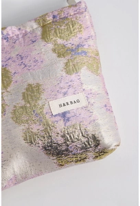 Gros plan sur tissu jacquard aux motifs floraux dorés et étiquette H&R BAG