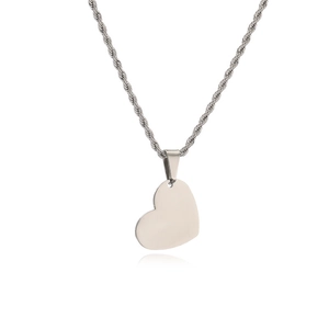 Macro detail of silver heart pendant with polished mirror finish on a twisted rope chain