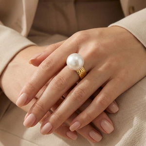 Detailed close-up of a golden hammered texture ring featuring a large white pearl