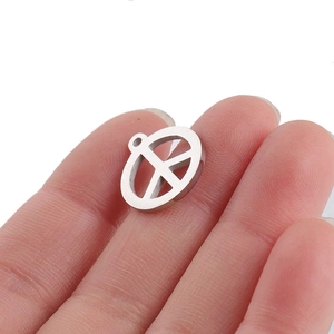 Gros plan détaillé d'un pendentif symbole de paix en acier inoxydable argenté sur les doigts