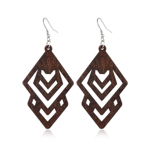 Macro detail of dark brown geometric hollow wooden earrings on a clean white background