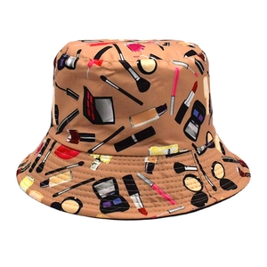 Detail of camel bucket hat featuring colorful cosmetic prints like lipsticks and brushes