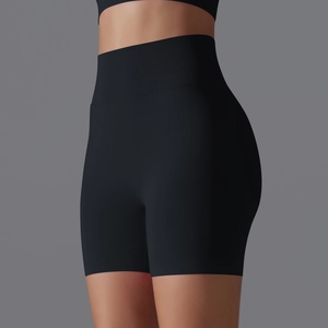 Detail of high-waisted seamless black yoga shorts showing elastic ribbed waistband and fabric