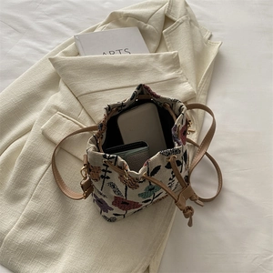 Ethnic embroidery bucket bag on a blazer, showing interior capacity and floral details