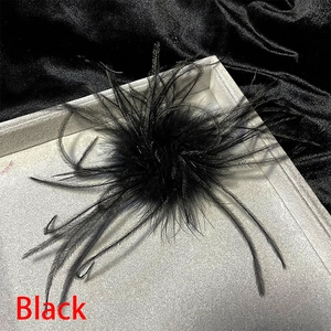 Detail of elegant black ostrich feather brooch pin featuring fluffy textured plumes